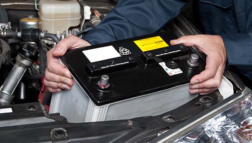 Service technician changing vehicle battery